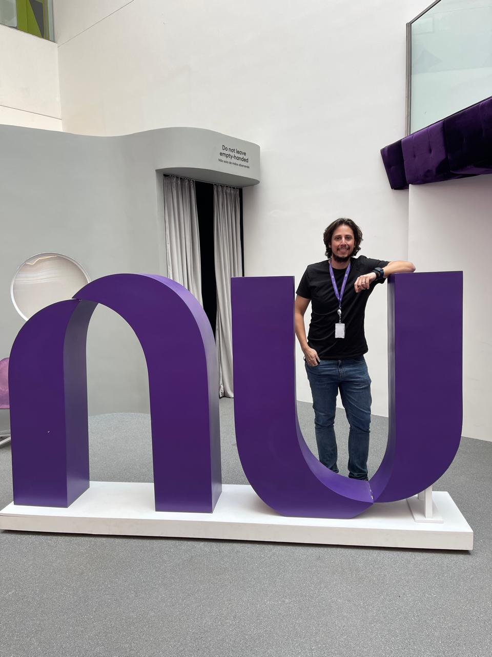Thiago Andrade ao lado do logotipo do Nubank